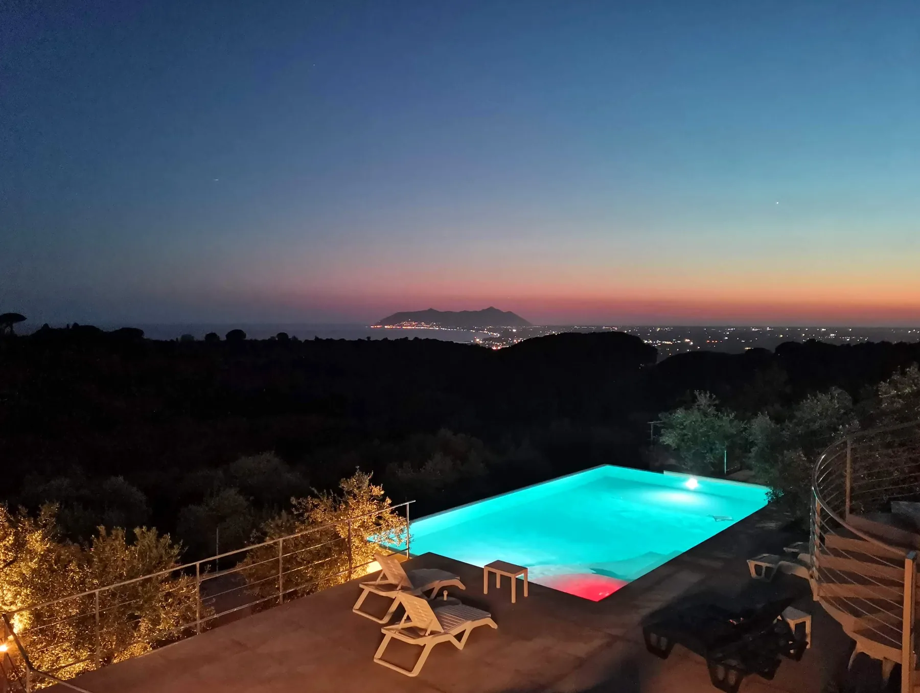 Piscina illuminata e Circeo di sera